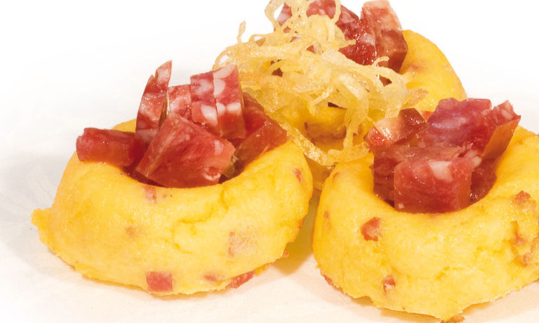 Small slices of gratinated “Polenta” with “Padus” salami cut into small cubes