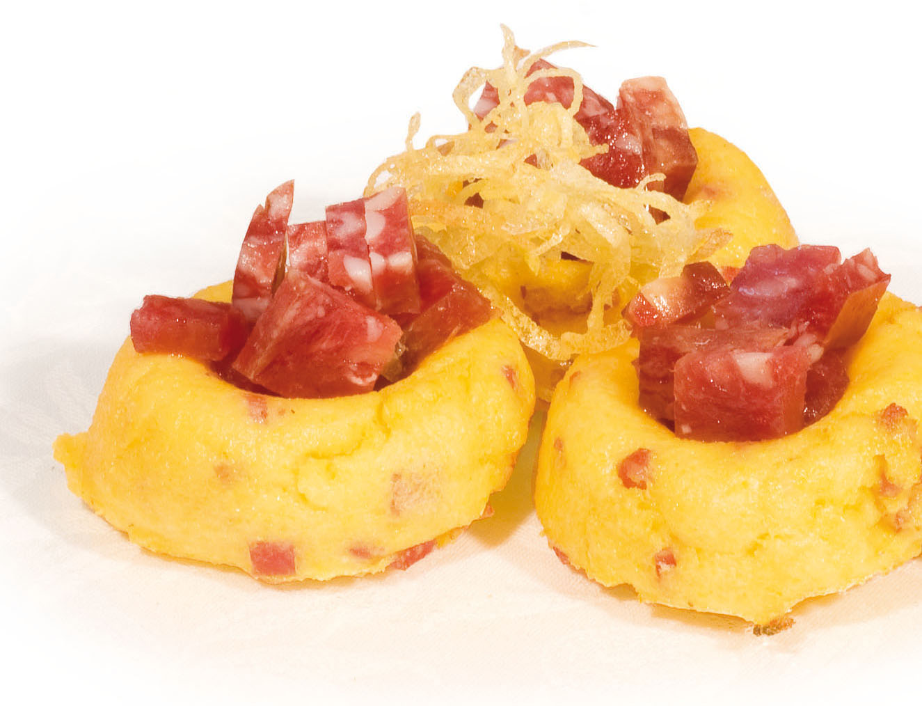 Small slices of gratinated “Polenta” with “Padus” salami cut into small cubes